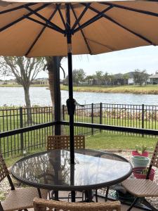 een glazen tafel met een parasol op een patio bij Loft à louer in Apollo Beach