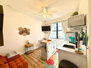 een woonkamer met een bank en een plafondventilator bij Loft à louer in Apollo Beach