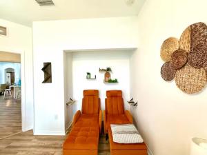 een woonkamer met twee oranje banken tegen een muur bij Loft à louer in Apollo Beach +6 foto's