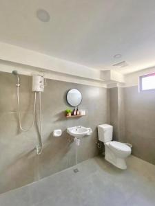 a bathroom with a shower and a toilet and a sink at EB Home Apartment in Mactan Island
