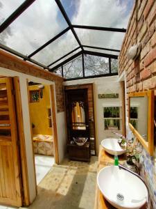a bathroom with two sinks and a glass ceiling at Jacamaki- Eco-lodge & Reserva Natural in Villa de Leyva