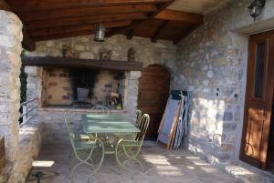 un patio con tavolo e sedie in un edificio in pietra di Bergerie de la bueges a Saint-André-de-Buèges