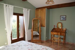 una camera con letto, specchio e tavolo di Bergerie de la bueges a Saint-André-de-Buèges