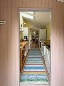 a hallway with a colorful rug in a kitchen at Summerhouse Close To Nature And Beach in Rørvig