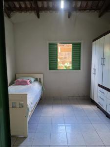 una camera da letto con un letto e una finestra di Casa temporada Cavalcante Goiás a Cavalcante