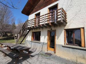a building with a wooden deck and a picnic table at Chalet spacieux 18 pers. avec jardin, 7 chambres, cheminées, animaux admis - Saint-Michel-de-Chaillol - FR-1-393-82 in Saint-Michel-de-Chaillol