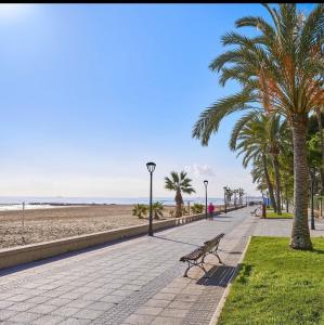 een bankje op een stoep naast het strand bij CASTELLON DELUXE in Castellón de la Plana