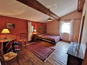 une chambre avec un lit, une table et une chaise dans l'établissement La maison du berger, à Cassagnes