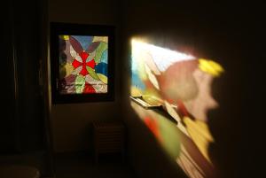 ein Schatten einer Person in einem Raum mit einem Buntglasfenster in der Unterkunft Bergerie du pic saint-loup in Saint-André-de-Buèges