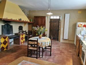 une cuisine avec une table avec un vase de fleurs dessus dans l'établissement La maison du berger, à Cassagnes