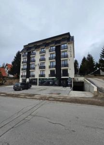 a large building with a parking lot in front of it at Kopaonik Alibi25 in Kopaonik