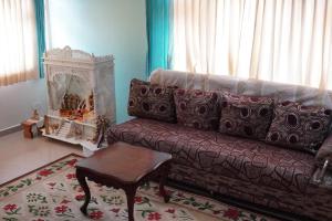 een woonkamer met een bank en een tafel bij Aarroh villa in Coonoor