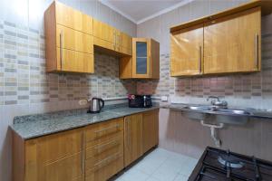 Elle comprend une petite cuisine avec des placards en bois et un évier. dans l'établissement Arena Hostel, à Hurghada 13 autres photos