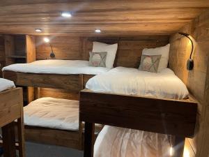 two bunk beds in a room with wooden walls at Chalet de ZORE in Morzine
