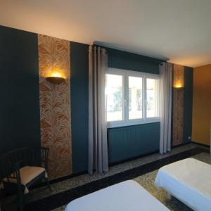 een kamer met twee bedden en een raam bij Louisiane in Sauvian