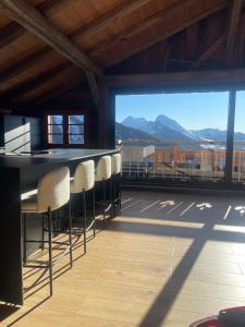 a balcony with chairs and a bar with a view at Chalet de ZORE in Morzine