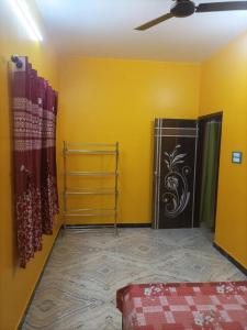 a room with a yellow wall and a door with a painting at Amullya Kanan Villa in Haldia +7 photos