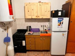 a small kitchen with a refrigerator and a stove at Depto San Bernardo céntrico2 in San Bernardo