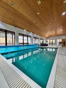 a large swimming pool with a wooden ceiling at Three Chalets Vrútky in Vrútky