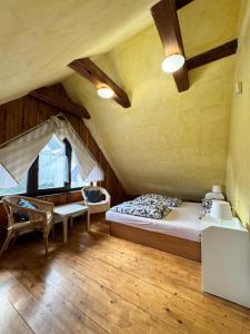 a bedroom with a bed and chairs in a attic at Three Chalets Vrútky in Vrútky