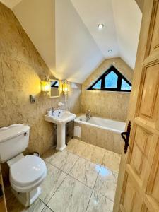 a bathroom with a toilet and a sink and a tub at Three Chalets Vrútky in Vrútky