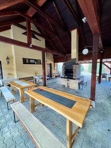 a large patio with wooden tables and a fireplace at Three Chalets Vrútky in Vrútky