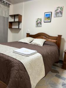 a bedroom with two beds and a book on the bed at Hotel Villalva, Cucunuba Cundinamarca in Cucunubá