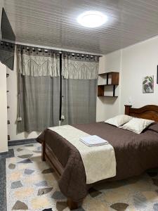 a bedroom with a bed and a window at Hotel Villalva, Cucunuba Cundinamarca in Cucunubá