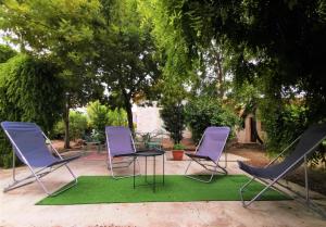 drie stoelen en een tafel op een groen tapijt bij Me kasa in Agde