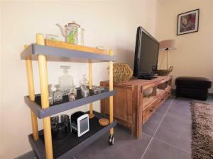 een woonkamer met een tv en een plank bij Me kasa in Agde