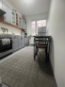 a kitchen with a table and a chair in it at Pokoje Metro Imielin in Warsaw