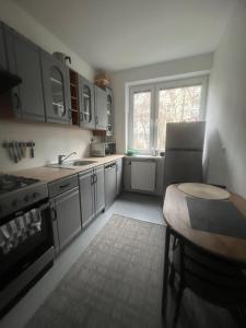 a kitchen with a sink and a table in it at Pokoje Metro Imielin in Warsaw