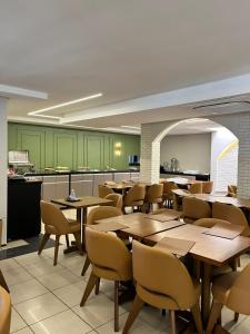 a restaurant with wooden tables and chairs and a kitchen at Pousada Lagoa Seca in Juazeiro do Norte