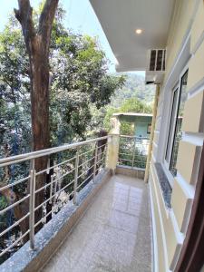 a balcony of a house with a tree at WoodsPicker in Rishīkesh