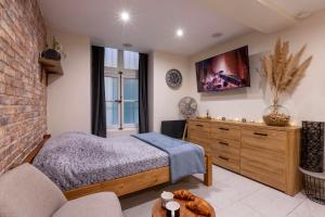 a bedroom with a bed and a tv on the wall at Au Spa de LLEA in Avignon