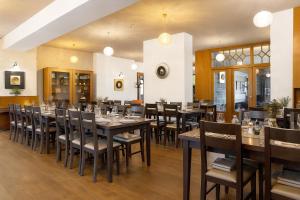 een eetkamer met houten tafels en stoelen bij REJVÍZ 1 Hotel & Spa in Rejvíz