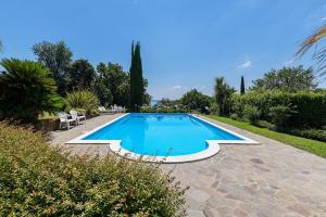 a swimming pool in a garden with chairs and trees at Daller Bianca by Whale Homes in Soiano del Lago +38 photos