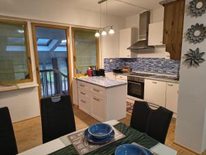 a kitchen with white cabinets and a table with chairs at Juls garden apartment in Tulln