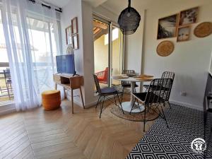 een woonkamer met een tafel, stoelen en een televisie bij Copatito in Cap d'Agde
