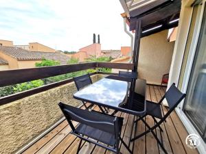 een tafel en stoelen op een balkon bij Copatito in Cap d'Agde