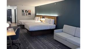 una camera d'albergo con due letti e un divano di La Quinta Inn & Suites by Wyndham Minot a Minot