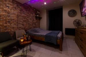 a bedroom with a bed and a brick wall at Au Spa de LLEA in Avignon