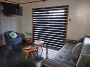 a living room with a couch and a chair and a table at Cabaña con Tinaja Privada Ruta 657 in Coihaique