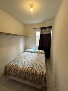 een kleine slaapkamer met een bed en een raam bij Casa in Bombinhas