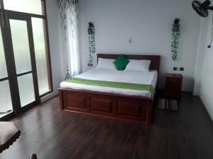 a bedroom with a bed with green and white sheets at Orchids Nest Vila Tg in Tangalle