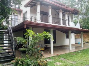 a house with a balcony and a staircase at Orchids Nest Vila Tg in Tangalle