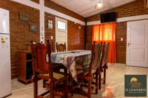 een keuken met een tafel, stoelen en een koelkast bij Cabaña El Chaparral Villa Dolores, Traslasierra 4 in Villa Dolores