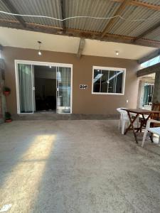 een lege kamer met een pingpongtafel en ramen bij Casa in Bombinhas