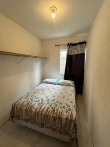 een kleine slaapkamer met een bed en een raam bij Casa in Bombinhas