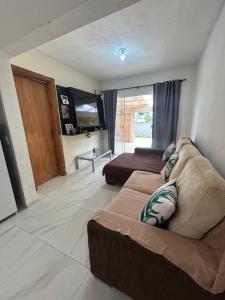 een woonkamer met een bank en een bed bij Casa in Bombinhas +39 foto's